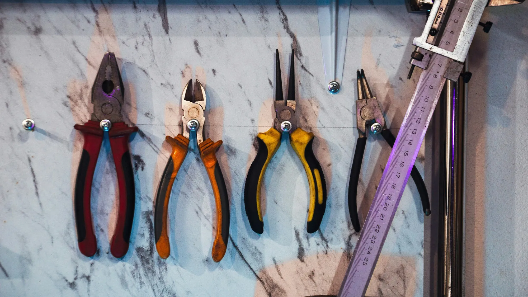 Electrician pliers and cutters hanging on a workshop wall