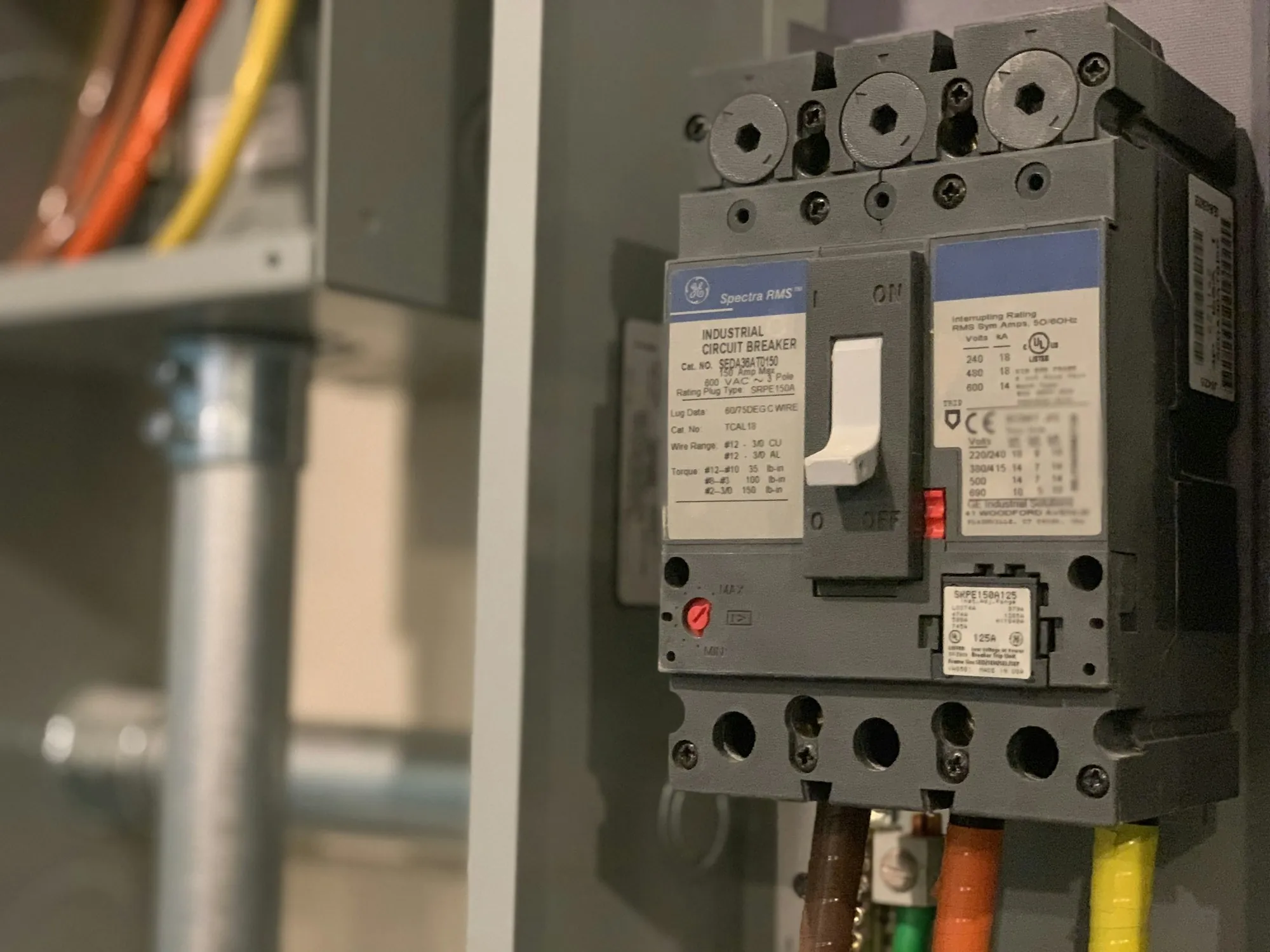 Industrial circuit breaker inside a gray enclosure
